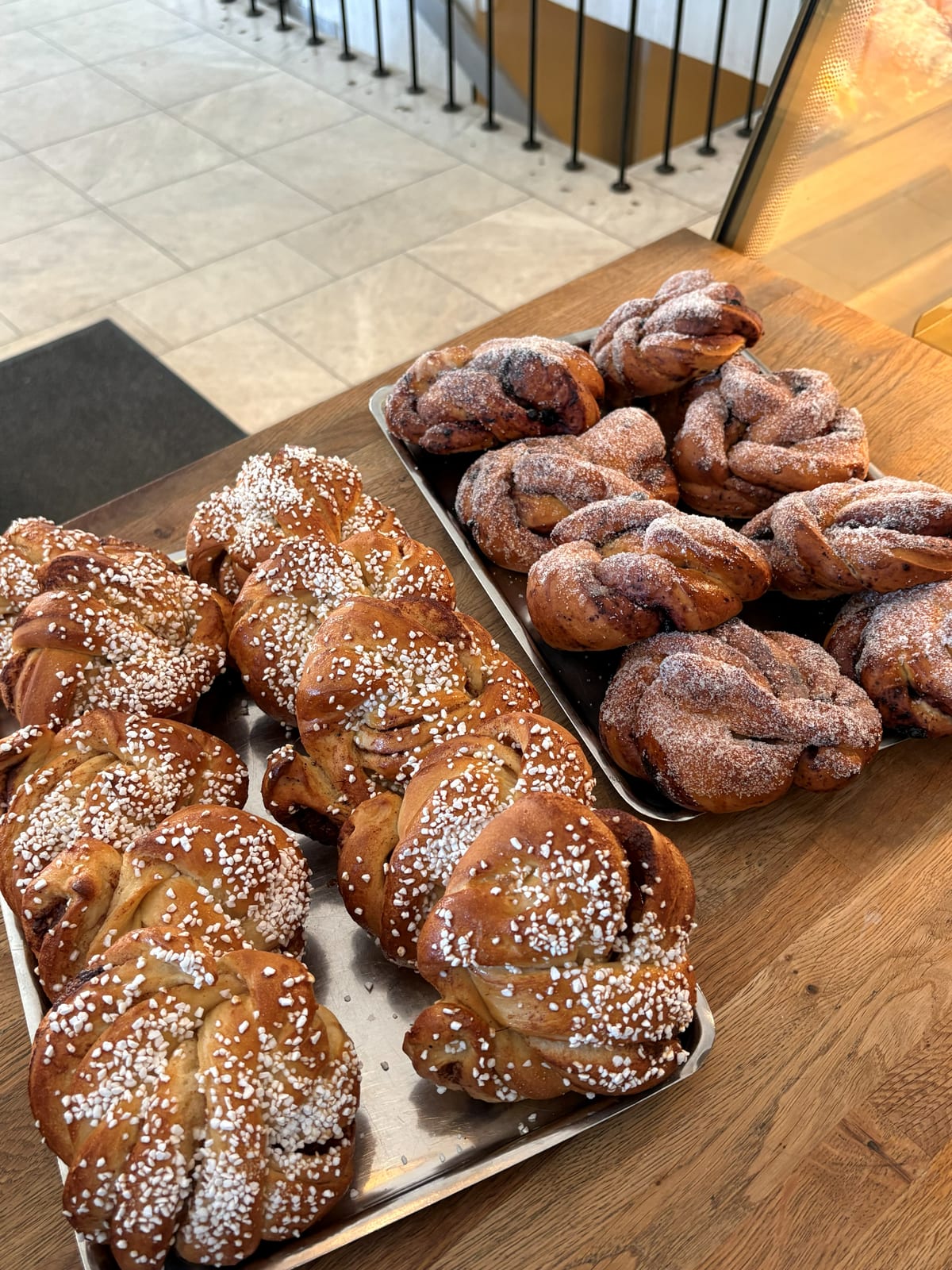 Två plåtar nybakat på disken: bullar med pärlsocker och sockrade knutar