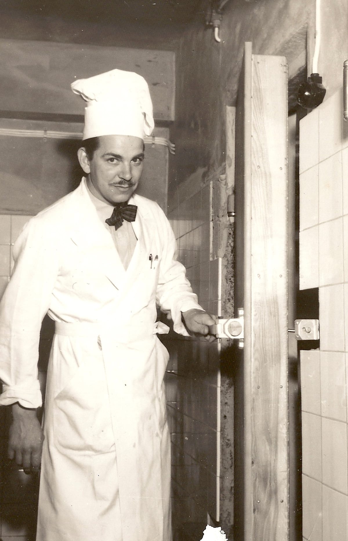 Owe Dackås i kockmössa och fluga, svartvitt foto